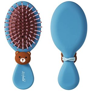 Frustrated child struggles with hair brush.
