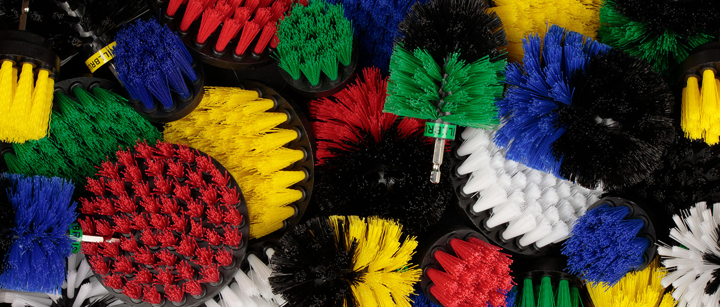 white soft Drill powered detailing brushes being used to clean car rims. Car cleaning drill brush