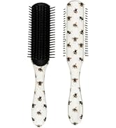 Two hair brushes with matching floral print handles - one with black bristles and one with white bristles arranged in different patterns.