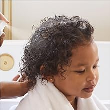 Image of detangler being sprayed onto child's hair