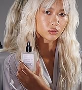 hair care hair oil in hand of blonde model with extensions in