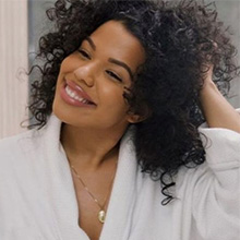 Woman smiling with heathy curly hair.