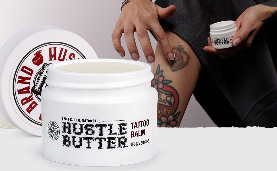 person with tattoos applying Hustle Butter Deluxe Tattoo balm, 1 ounce travel sized tattoo aftercare