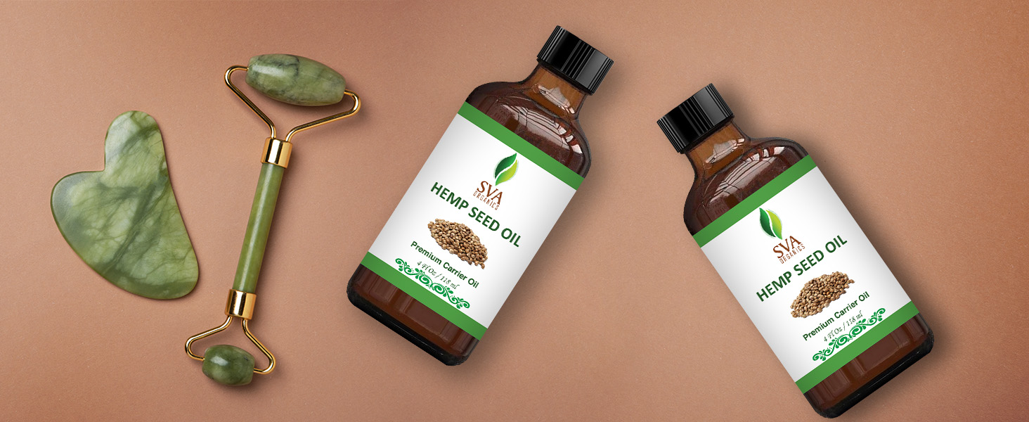 Two amber glass 4oz bottle of hemp seed carrier oil placed beside face roller massager for skincare