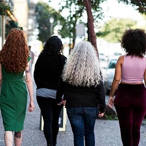 four curly haired woman walking away from the camera