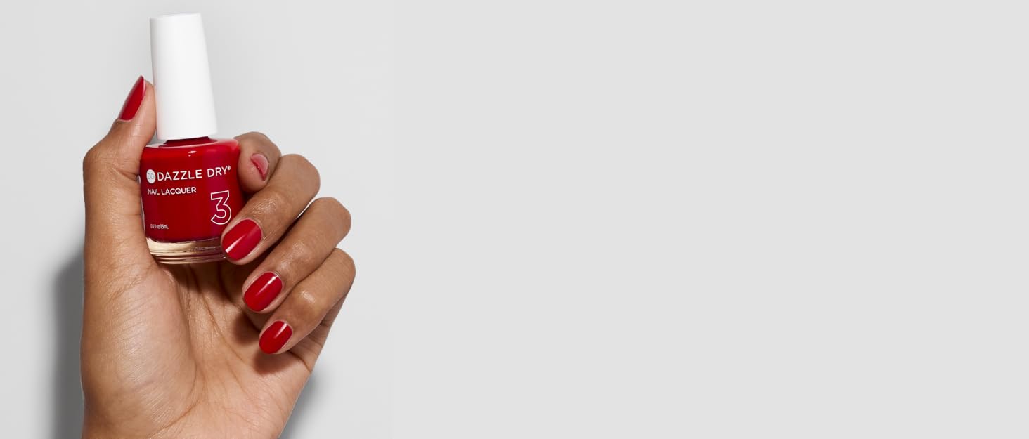 Woman wearing red Dazzle Dry nail polish holding bottle of red nail polish