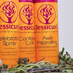 six bottles of different product with a white background on a brown table with lavender underneath