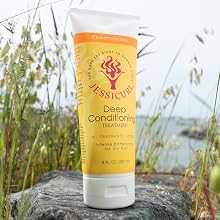 squeeze bottle of conditioner on a rock surrounded by water reeds with the water in the background