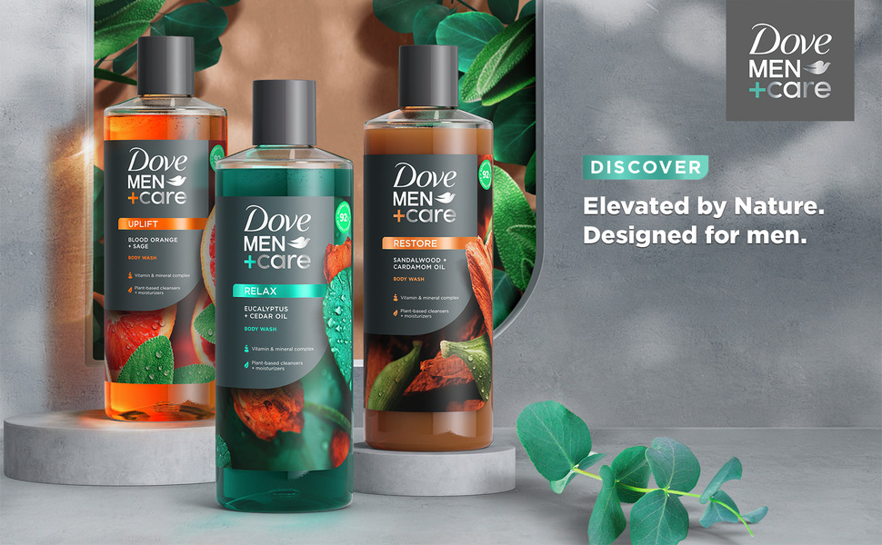 Three body wash bottles from the same Dove Men+Care line with leaves behind and next to them.
